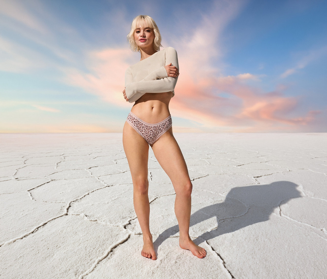 Frau steht barfuß in sloggi GO Crush Hipster C3P, multi col. rosé vor blauem Himmel.