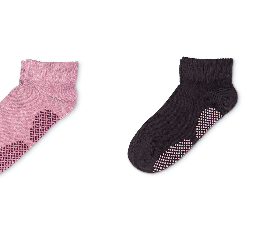 Zwei Paar Yogasocken: ein Paar in Rosa und ein Paar in Dunkelbraun.