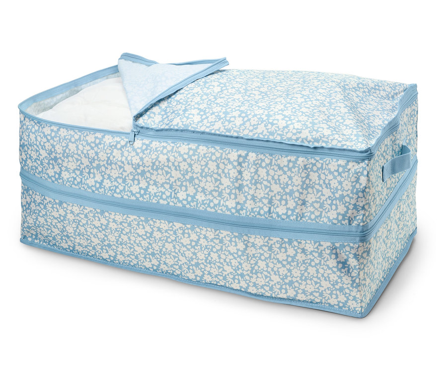 Eine Aufbewahrungsbox mit Reißverschluss und blauem Blumenmuster, teilweise geöffnet, wodurch der weiße Stoff im Inneren sichtbar wird.