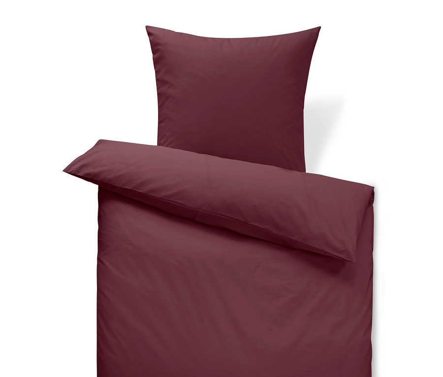 Weinrote Bettwäsche mit Kissen und Bettdecke.