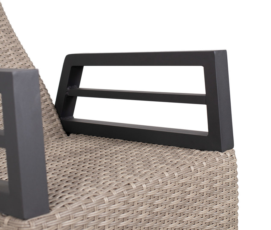 Detailaufnahme eines beige-farbenen Rattansessels mit dunkelgrauen Metallarmlehnen.