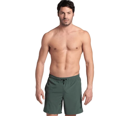 Mann steht oberkörperfrei und trägt grüne arena Badeshorts Evo.
