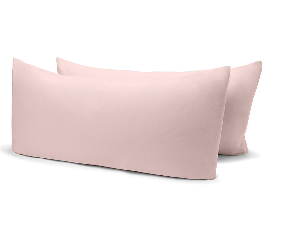 Zwei hellrosa Kissen liegen nebeneinander auf einem weißen Hintergrund.