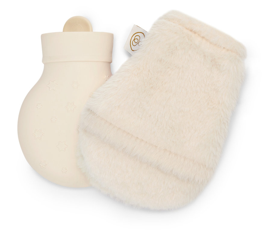 Cremefarbene Gummi-Wärmflasche mit Sternen neben cremefarbenem, flauschigem Handschuh.