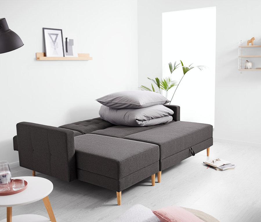 Ein Federkern-Eckschlafsofa mit Stauraumbank steht im Wohnzimmer.