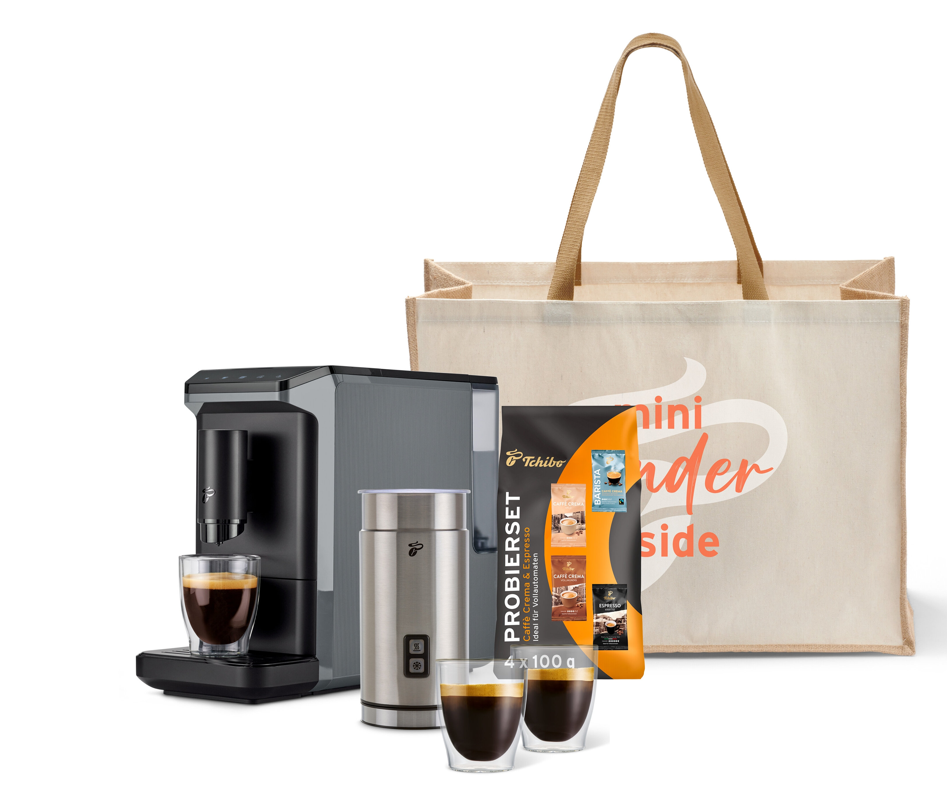 Kaffeemaschine, Milchaufschäumer, zwei Tassen Kaffee und eine Tragetasche mit Aufschrift.