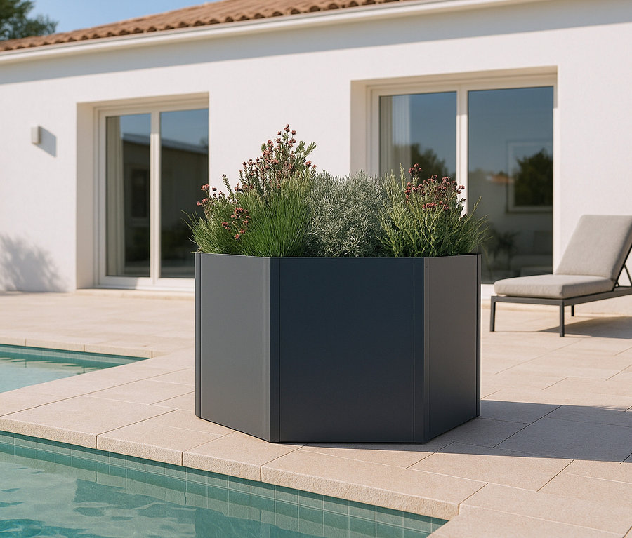 Blumenkasten mit Pflanzen auf einer Steinterrasse neben einem Pool.