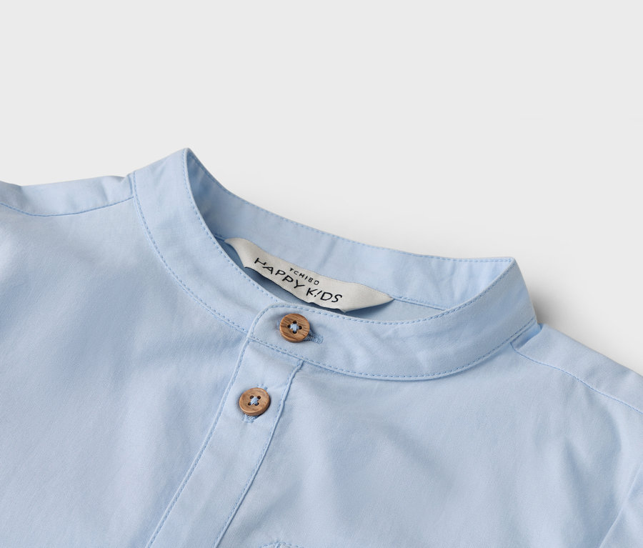 Detailaufnahme eines hellblauen Hemdes mit zwei Knöpfen und einem Kragen.