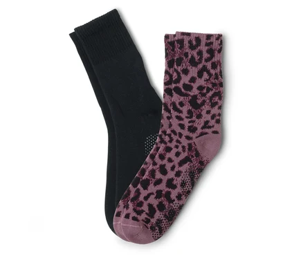 Ein Paar Socken, eine schwarz und eine lila mit Leopardenmuster, liegen übereinander.