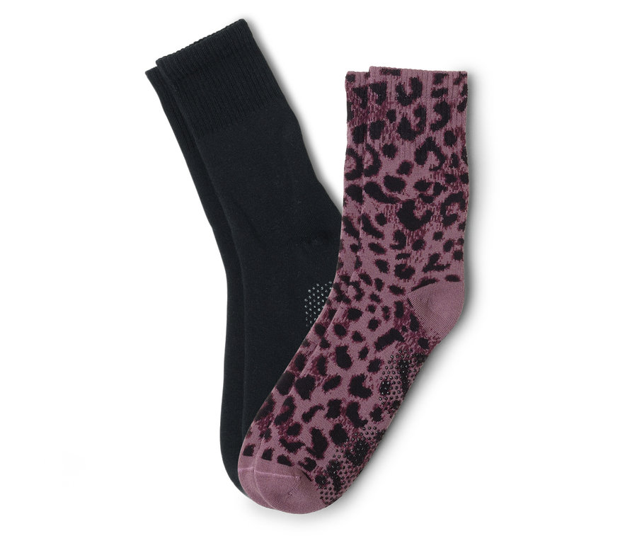 Ein Paar Socken, eine schwarz und eine lila mit Leopardenmuster, liegen übereinander.