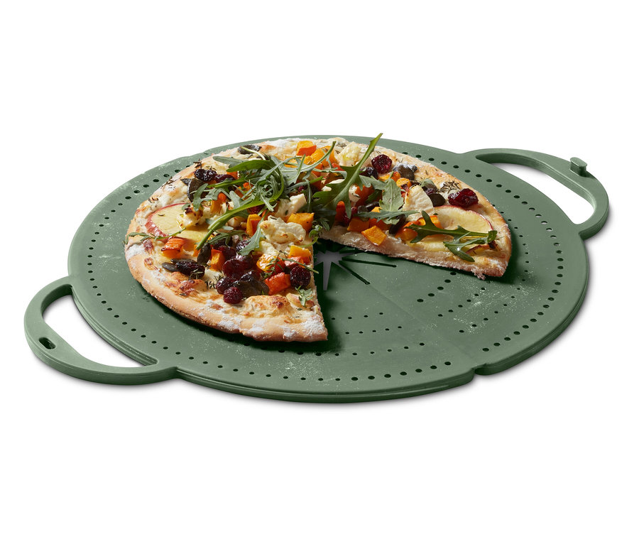 Eine Pizza mit Gemüsebelag liegt auf einem grünen Pizzablech.
