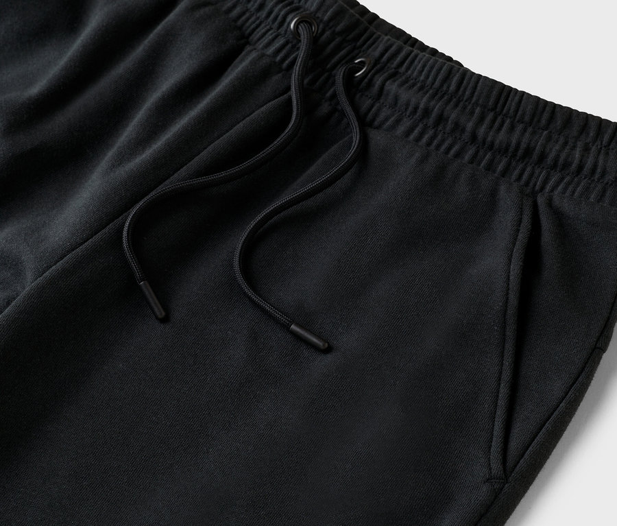 Nahaufnahme einer schwarzen Jogginghose mit Kordelzug und Taschen.