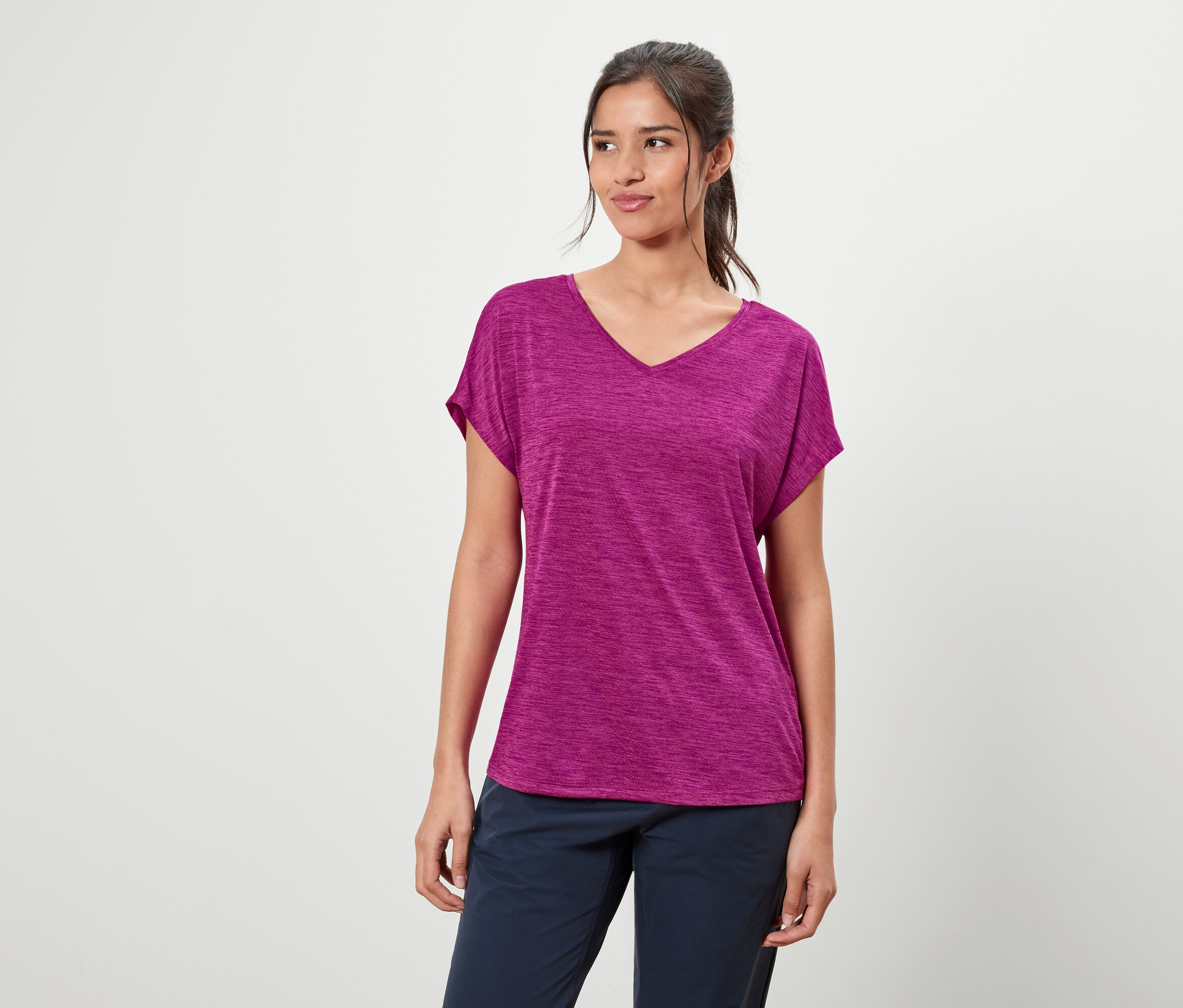 Frau trägt ein violettes T-Shirt und blaue Hosen.