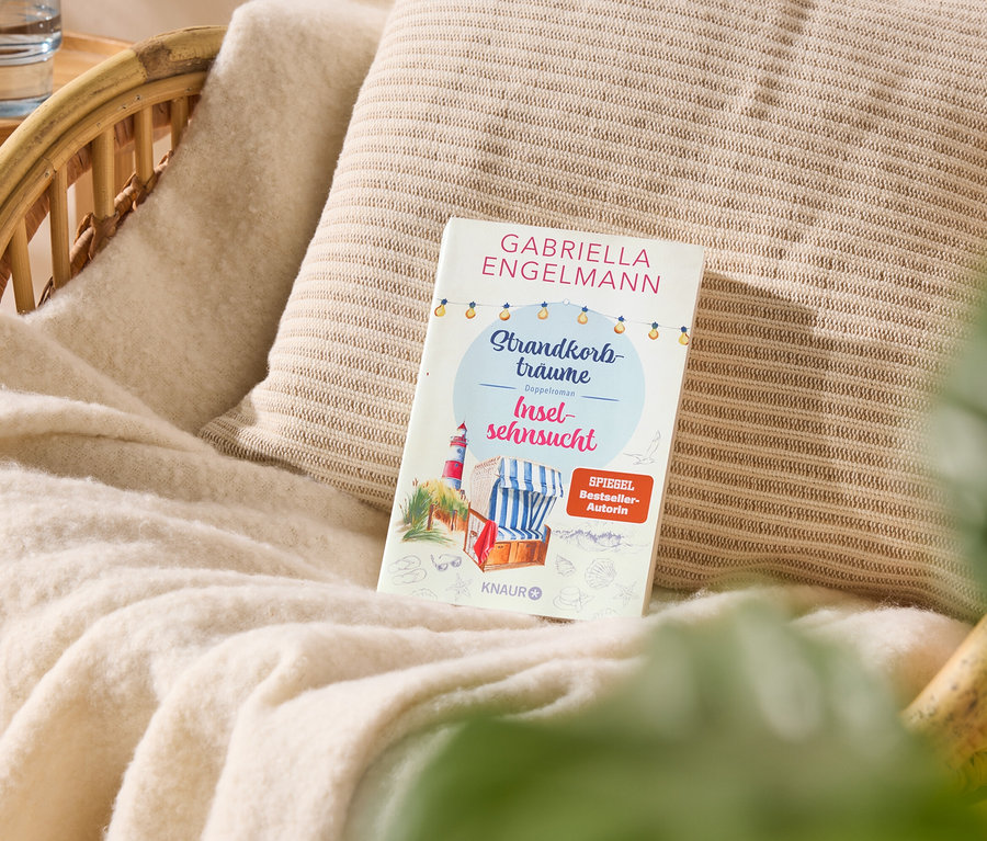 Auf einem Sessel liegt ein Buch mit dem Titel "Strandkorbträume Inselsehnsucht" von Gabriella Engelmann.