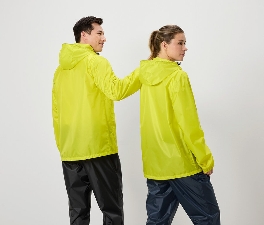 Ein Mann und eine Frau stehen zusammen und tragen gelbe Regenjacken und dunkle Regenhosen.