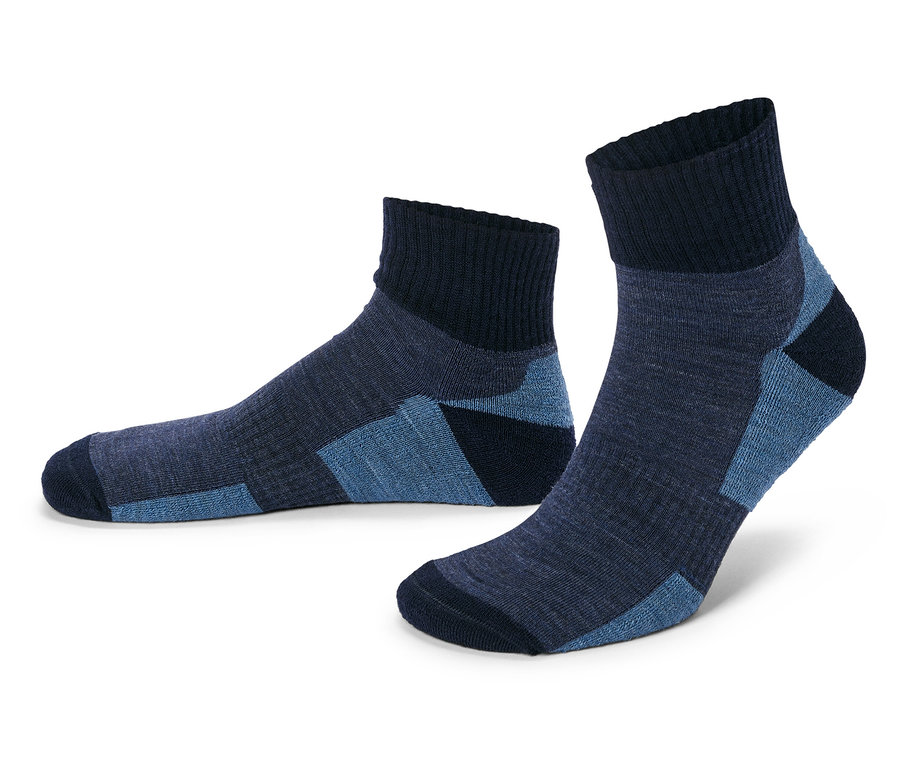 Ein Paar marineblaue Socken mit blauen Akzenten, eine liegend und eine stehend, vor einem weißen Hintergrund.
