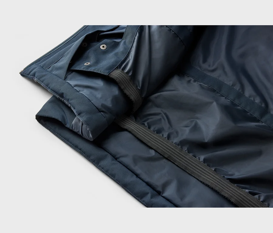 Nahaufnahme der Innenseite einer dunkelblauen Jacke mit glänzendem Futter, Druckknöpfen und einem gerippten Gurtband.