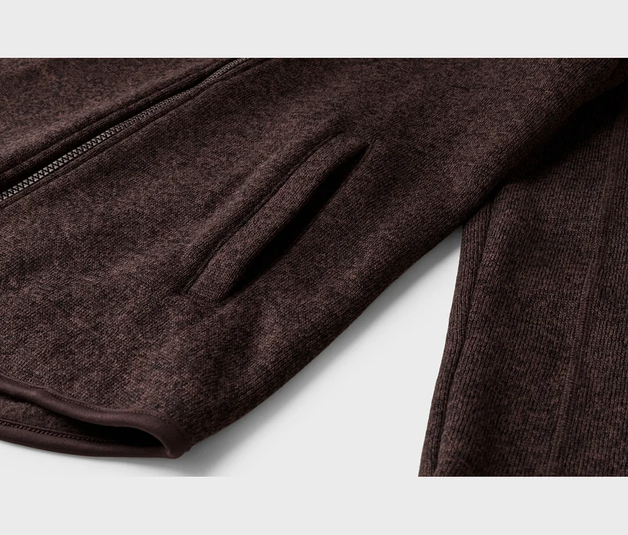 Nahaufnahme einer dunkelbraunen, melierten Strickjacke mit teilweise sichtbarem Reißverschluss, einer integrierten Seitentasche und gerippter Textur rechts.