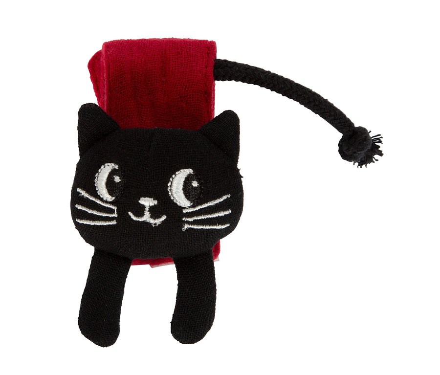 Ein schwarzes, katzenförmiges Spielzeug mit weißen gestickten Augen, Nase und Schnurrhaaren, befestigt an einer roten Stoffschlaufe mit einer schwarzen geflochtenen Kordel.