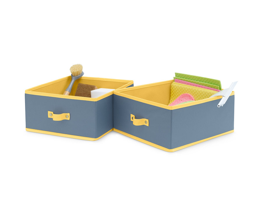 Zwei große Schubladen-Ordnungsboxen, grau mit gelbem Rand, eine mit Bürste, Schwamm und weißem Würfel, die andere mit Tüchern und Abzieher.