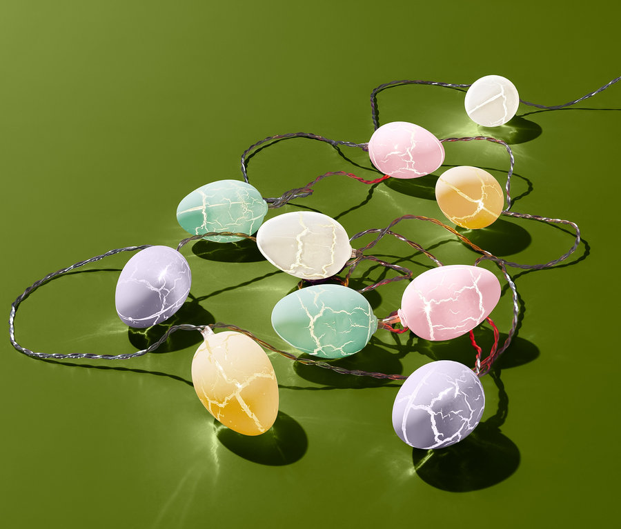 LED-Lichterkette mit eiförmigen Lichtern auf grünem Grund.