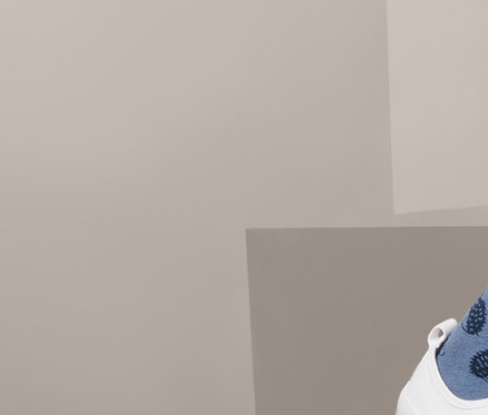 Lächelndes Mädchen in Jeanskleid und 2 Thermostrumpfhosen mit Igelmuster.