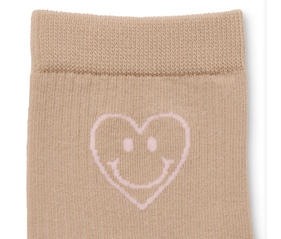 Detailaufnahme einer beigen Socke mit einem rosa Herz-Smiley-Motiv.