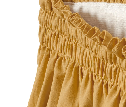 Detailansicht eines gelben NAH/STUDIO Rocks aus Bio-Baumwolle mit elastischem Bund.