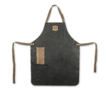 Eine schwarze Grillschürze mit braunen Lederdetails und einer Tasche.