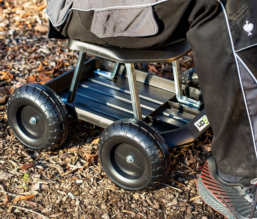 Ansicht eines schwarzen Rollsitz-Gartenwagens auf Rinde.