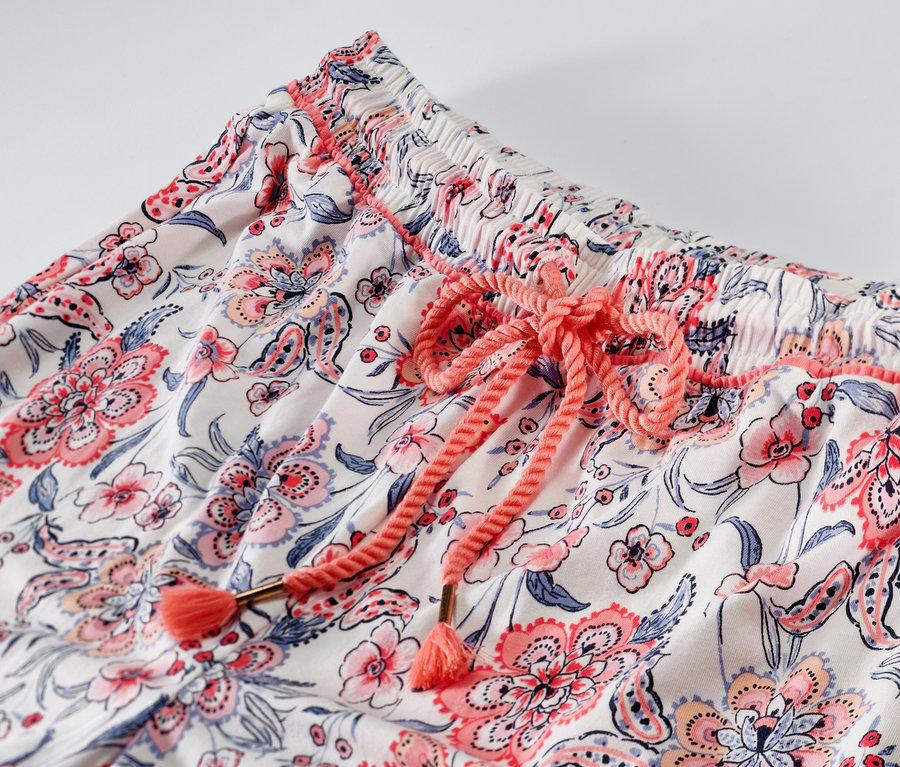 Detail einer Pyjamahose mit Blumenmuster und Kordelzug.