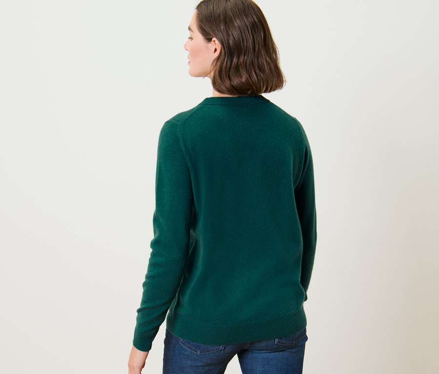 Frau trägt grünen Feinstrickpullover mit Cashmere und Jeans.
