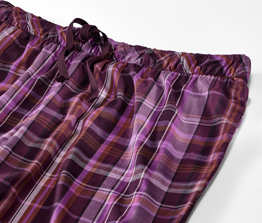 Detailansicht einer Web-Pyjamahose mit lila-schwarzem Karomuster.