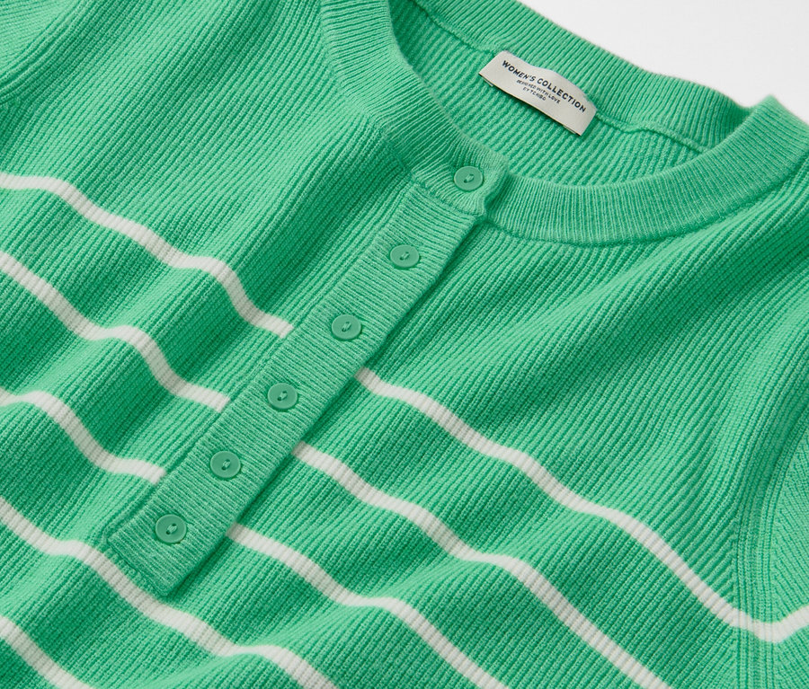 Detailansicht eines gestreiften Feinstrickpullovers in Grün und Weiß mit Knopfleiste.