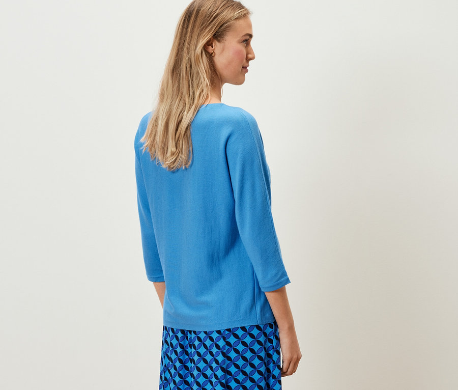 Frau trägt kobaltblauen Merino-Feinstrickpullover.