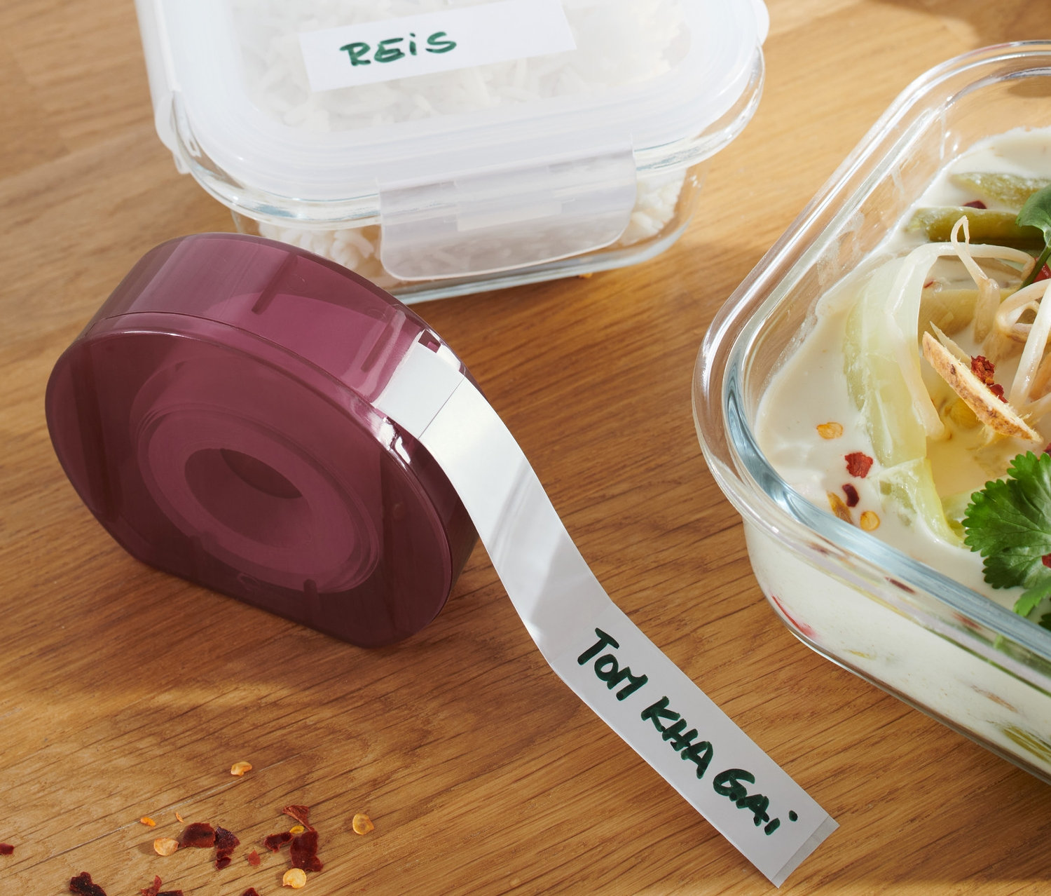 Etikettenspender, Behälter mit Reis und Suppe auf einem Holztisch.