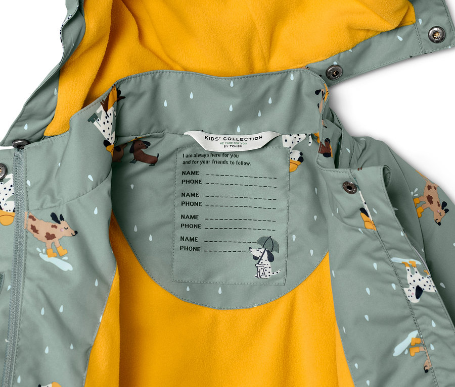 Detailansicht einer Kinder Thermo-Regenjacke mit Hundeprint und gelbem Futter.