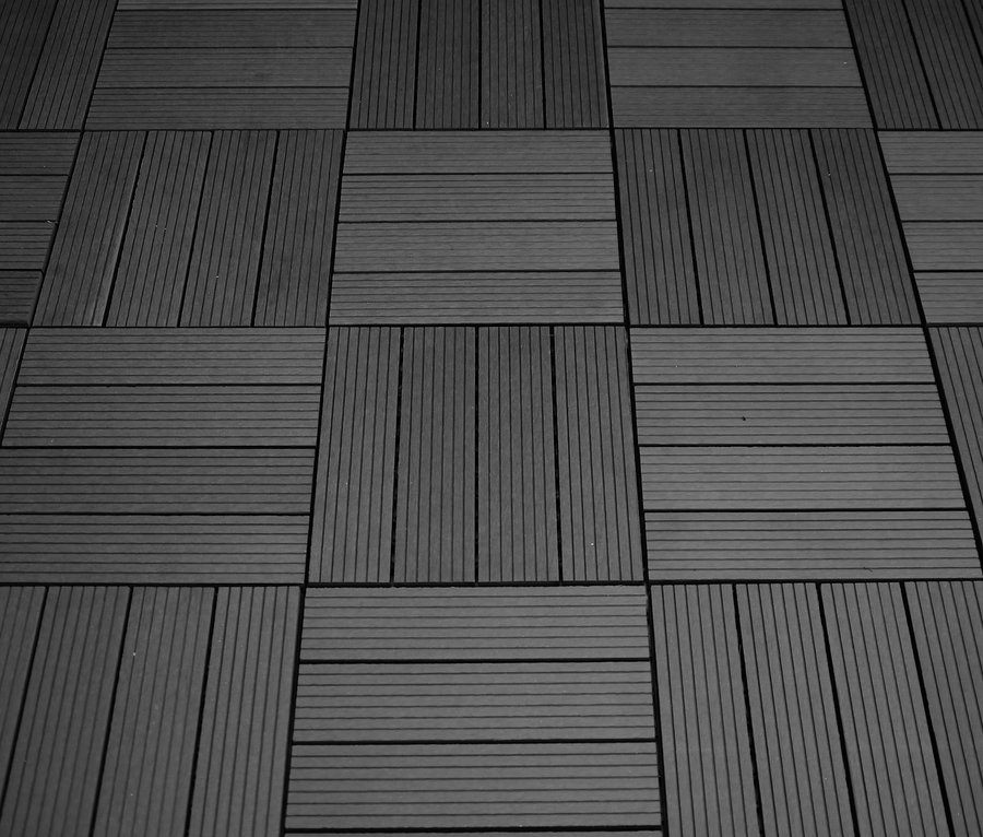 Schwarz-Weiß-Foto von quadratischen 30 x 30 cm WPC Terrassenfliesen, die abwechselnd vertikal und horizontal angeordnet sind.