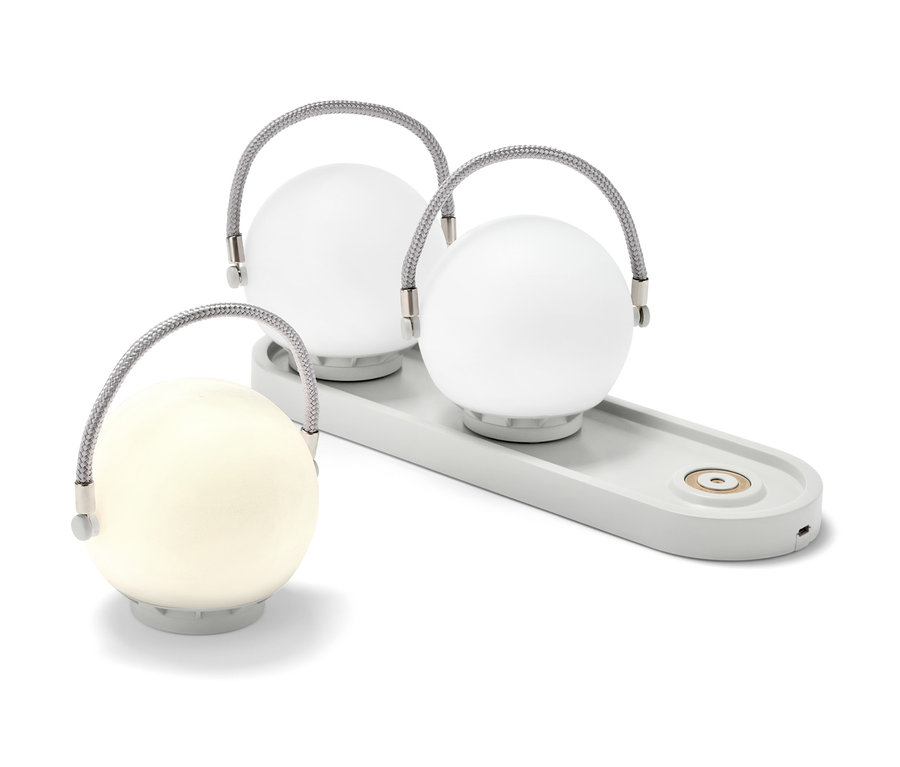 Zwei LED-Akku-Tischleuchten auf einer grauen Ladestation und eine LED-Akku-Tischleuchte daneben.