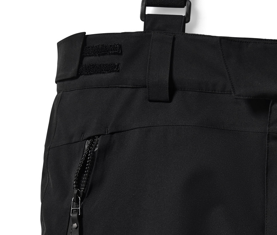 Detailaufnahme einer schwarzen High-Tech-Skihose mit Reißverschluss und Hosenträgern.