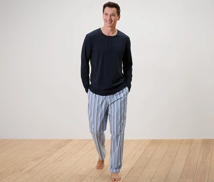 Mann geht, trägt einen Pyjama mit gewebter Hose.