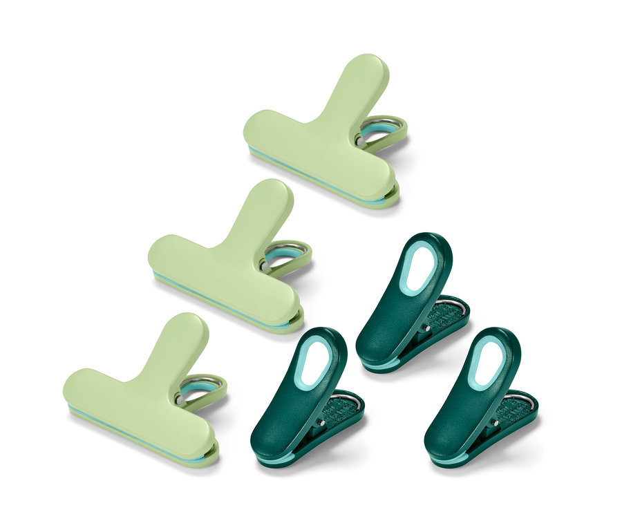 Sechs Aromaclips, drei hellgrüne und drei dunkelgrüne, liegen auf einem weißen Hintergrund.