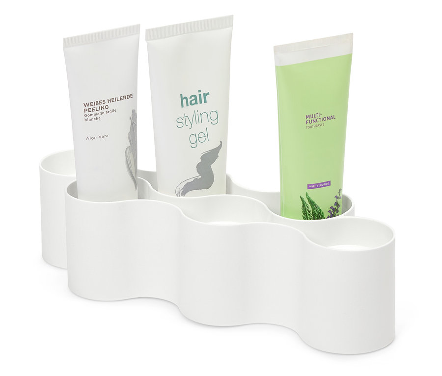 Drei Tuben Kosmetik in einem weißen Plastikhalter.