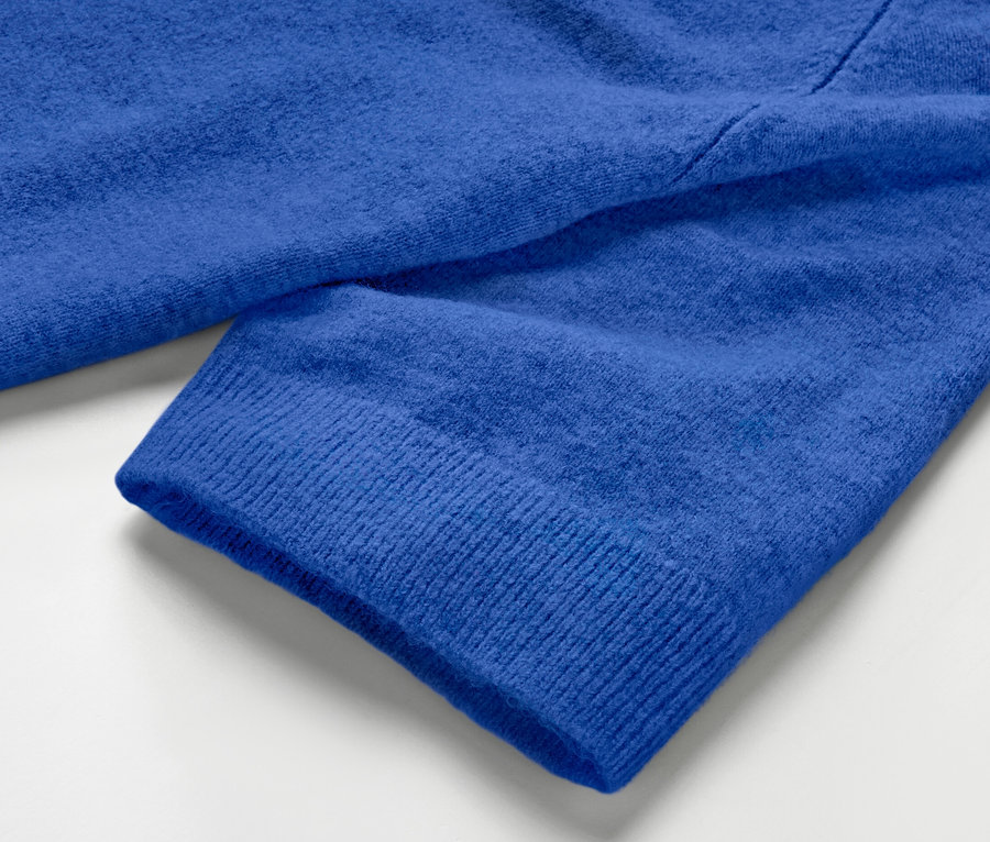 Detailansicht eines kobaltblauen Strickpullovers.