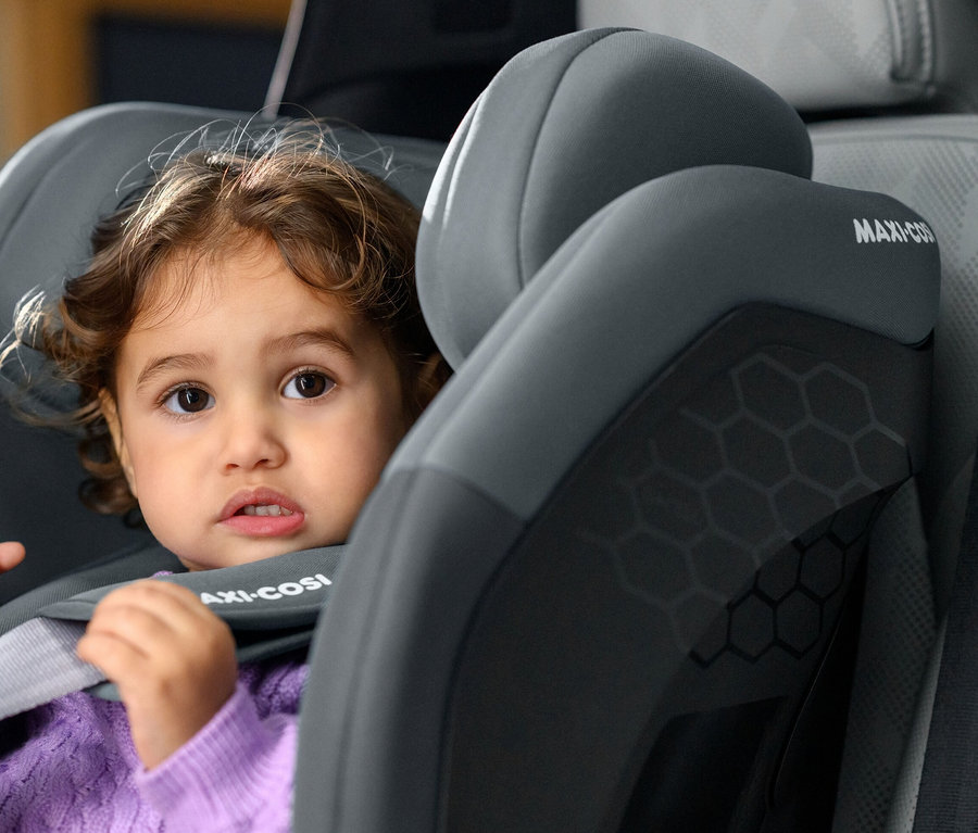 Kleines Kind sitzt in einem grauen Maxi-Cosi Titan S i-Size Kinderautositz.
