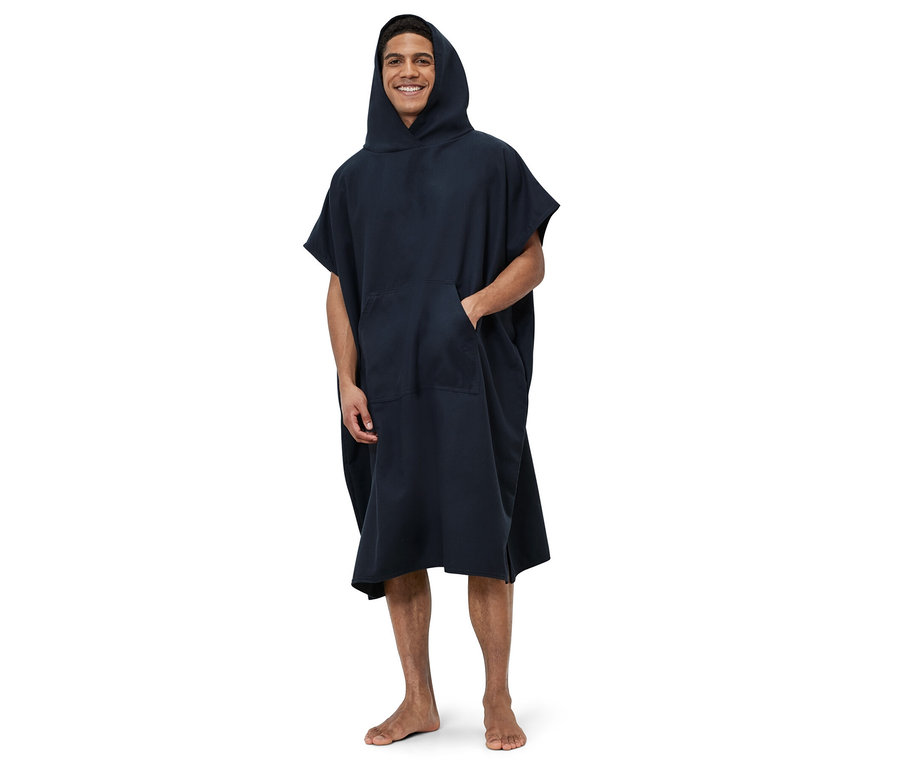 Ein Mann steht und trägt einen blauen Umzieh-Poncho.