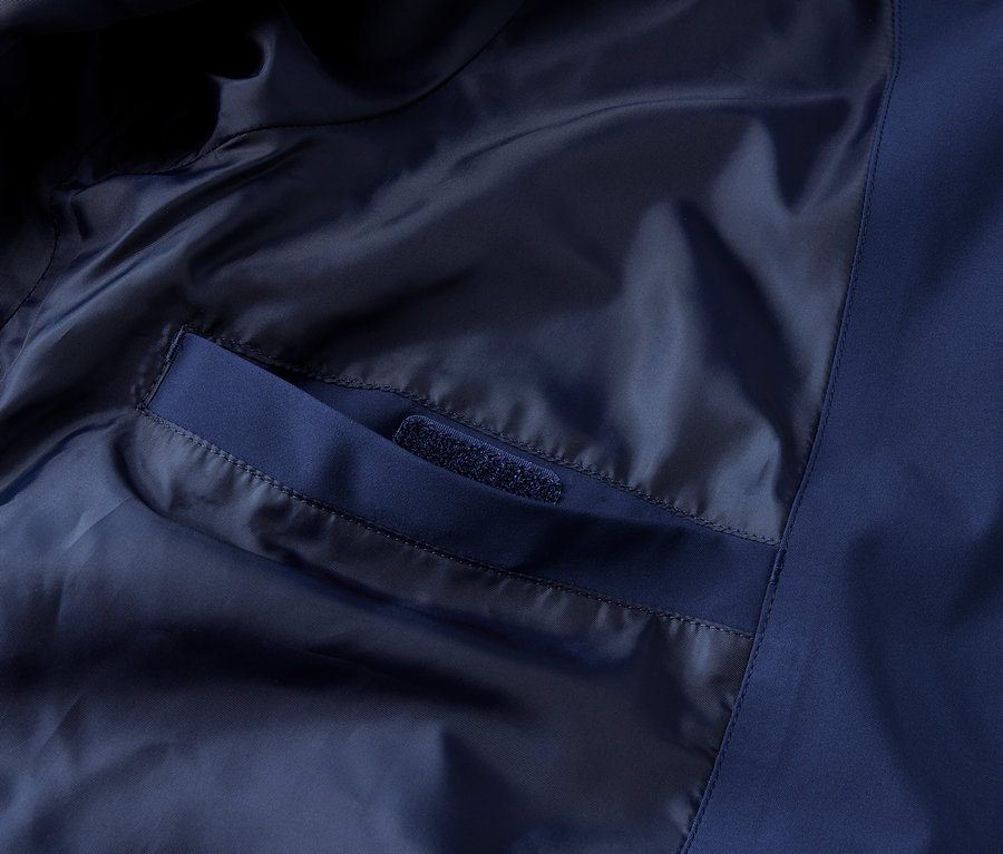 Detailaufnahme einer blauen Funktions-Outdoorjacke mit Innentasche.