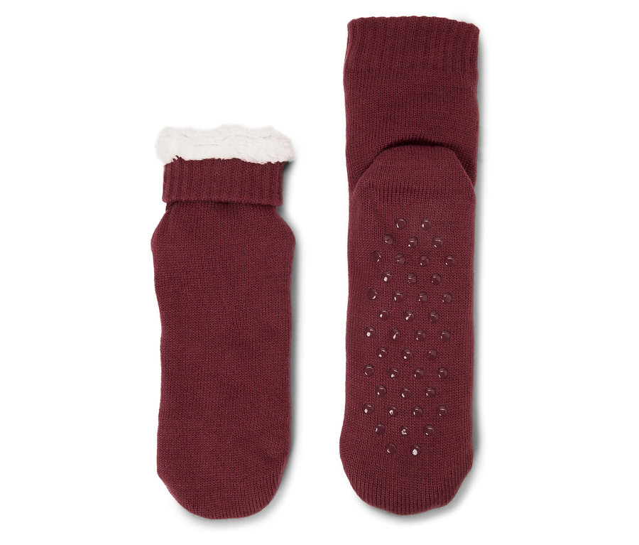 Zwei bordeauxrote Socken. Eine hat einen weißen Plüschrand, die andere Anti-Rutsch-Punkte.