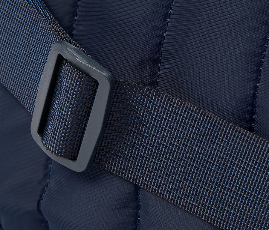 Nahaufnahme einer marineblauen gesteppten Tasche mit blauem Riemen und Schnalle.