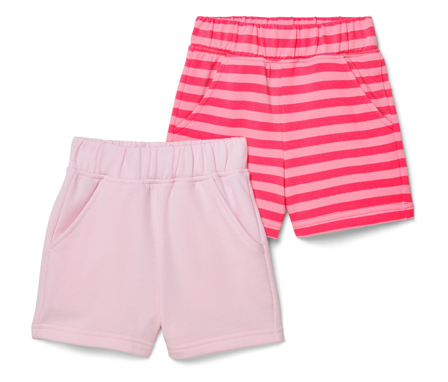 Zwei kurze Hosen liegen auf einem weißen Hintergrund, eine rosa und eine rosa-gestreifte.